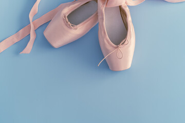 simple composition of a cutout of a pair of classical dance shoes on a plain blue background