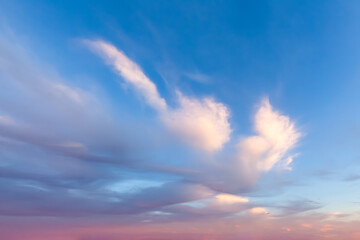 Wispy clouds with blue and pink background