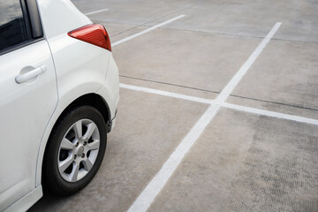 close up of modern car in parking lot, grunge surface of street, car parked in the right position in outdoor shopping plaza carpark area, shallow depth of field - obrazy, fototapety, plakaty