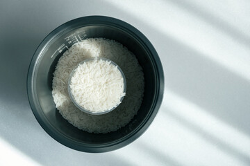 milled rice in pot, rice cooking preparation, measuring cup