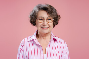 Portrait of positive senior 70 years old woman wearing eyeglasses and stylish casual clothes