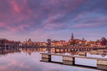 View on the historic harbor and center of Blokzijl, a typical and historic town in the Weerribben Wieden,  with monumental buildings, golden age trade center, horizontal shot during colorful sunset