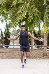 Muscular black athlete working out with jumping rope