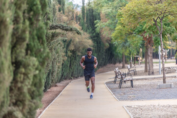 African American man in activewear jogging in park