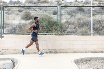 Determined African American athlete jogging in park during workout