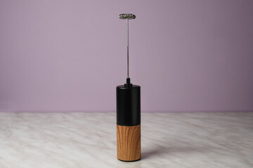 Hand milk frother and on marble table. Side view. © Photo