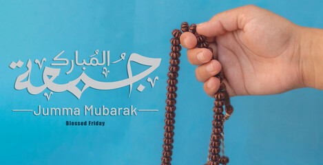 Jummah Mubarak blessed happy Friday Arabic Modern calligraphy, Selective focus image hand of Muslim...