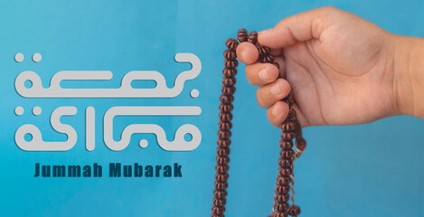Jummah Mubarak blessed happy Friday Arabic Modern calligraphy, Selective focus image hand of Muslim...