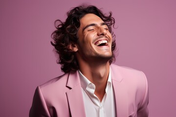 An exuberant male model laughing heartily against a soft lavender pink background. - obrazy, fototapety, plakaty
