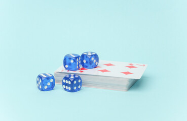 Stack of playing cards and dice on blue background