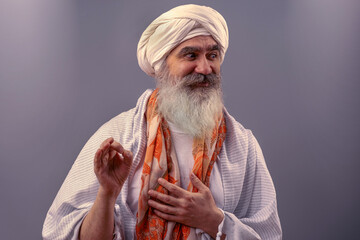 Senior man in a turban is associated with a Hindu, Jain, Buddhist.  Prayer gesture.