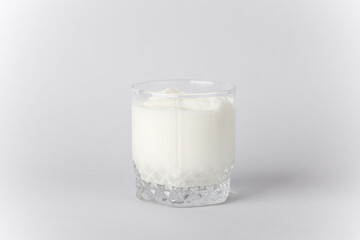 Yogurt in glass on gray background