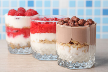 Homemade layered Desserts in a glass cups with yogurt and chocolate balls on table