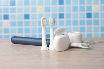 Modern smart ultrasonic toothbrush with heads and dental floss on the table
