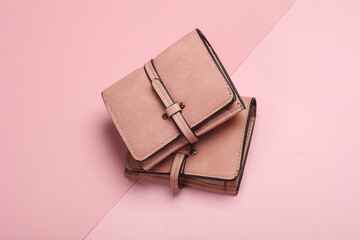 Two pink leather wallets on a pink background