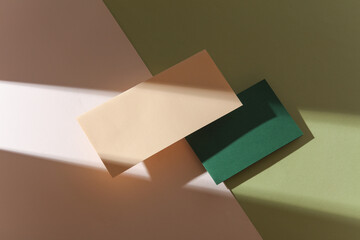 Group of floating colored blank cards sheet with shadow on beige green background. Minimalism...