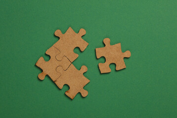 Wooden pieces jigsaw puzzle on green background
