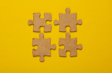 Obraz premium Wooden pieces jigsaw puzzle on yellow background