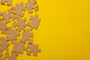 Wooden pieces jigsaw puzzle on yellow background