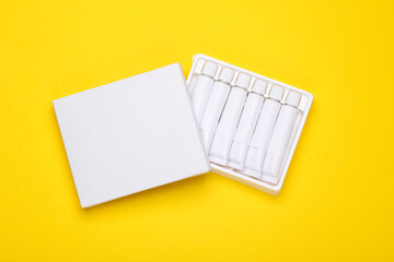 Set of white empty tubes of acrylic or oil paint for creativity on yellow background. Template for design, mockup
