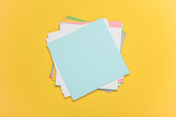Square sheets of paper for origami creativity on yellow background