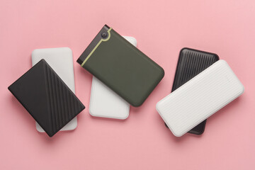 Power banks and external hard drives on a pink background