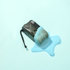 Creative minimalist layout. Camera with slime on a blue background. Surreal summer idea. Conceptual pop