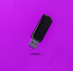 Usb flash drive levitating on purple background with shadow