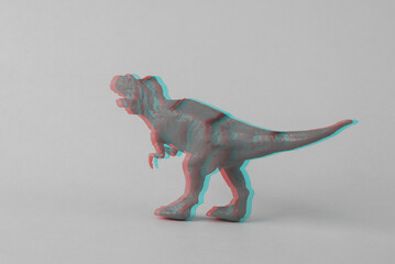 Toy dinosaur tyrannosaurus rex on gray background. Minimalism creative layout. Glitch effect