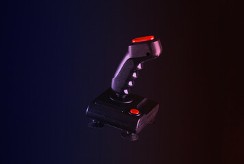Vintage arcade video game joystick isolated on black background in neon light © splitov27