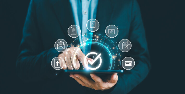 Businessman use smartphone control data correct sign, check mark document icon approve quality assurance, web guarantee concept. Online paperless doc agreement. Electronic form sorfware management