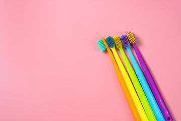 A bright composition of toothbrushes of different colors. Bright background with toothbrushes, free space for text or logo.
