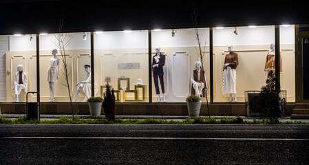 Night showcase of a clothing store. Night shop and mannequins in clothes.