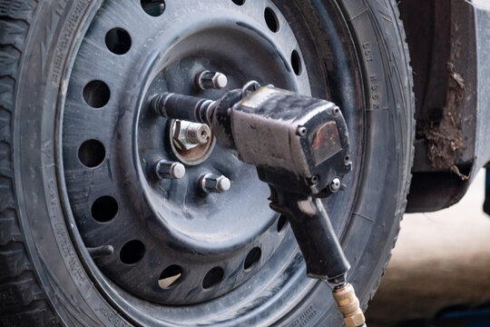 Pneumatic wrench on wheel nut
