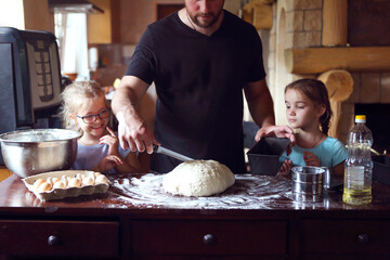 Children cooking homemade bread with there father