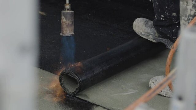 Dachdecker mit Bunsenbrenner und Dachpappe