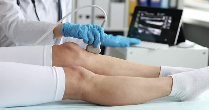 Doctor conducts ultrasound examination of the knee joint and lower leg of patient in clinic closeup. Pain in lower leg causes and consequences