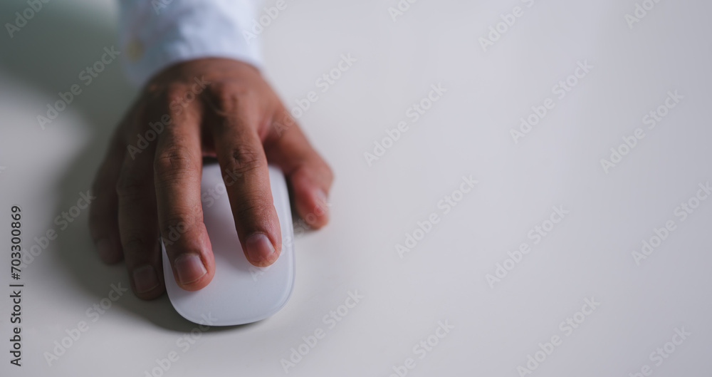 Poster close up of hand using on white mouse and clicking on office table