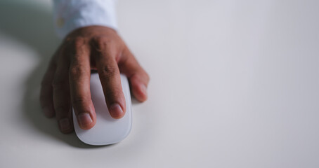 Close up of hand using on white mouse and clicking on office table