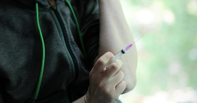 Drug addict injects heroin or drug into vein using injection needle. Drug addiction and depression