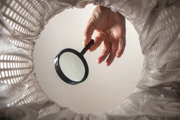 throw a magnifying glass in a trash can, magnifier in hand inside view, bad search concept