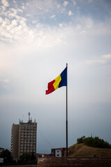 Romanian national Flag in wind in background with beautiful blue sky