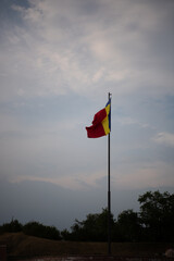 Romanian national Flag in wind in background with beautiful blue sky
