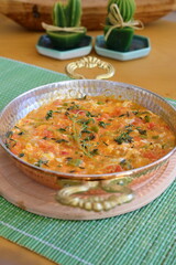 Homemade omelette with vegetables on white plate on wooden background.