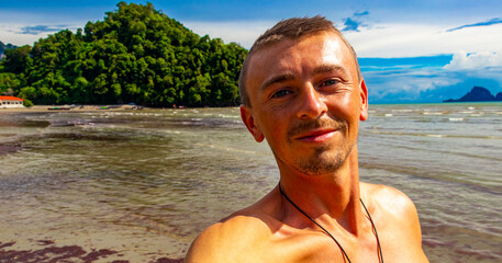 Man takes selfie photo tropical paradise beach Ao Nang Krabi Thailand.