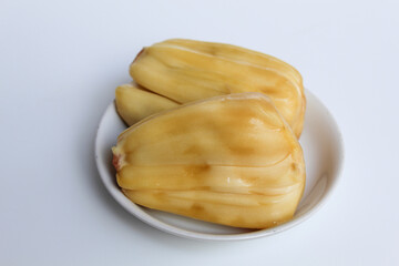 Yellow Jackfruit flesh from Artocarpus heterophyllus, on small white plate, isolated on white background