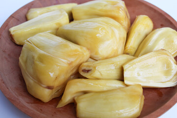 Yellow Jackfruit flesh from Artocarpus heterophyllus, on wooden plate, isolated on white background