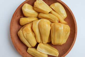 Yellow Jackfruit flesh from Artocarpus heterophyllus, on wooden plate, isolated on white background, flat lay or top view