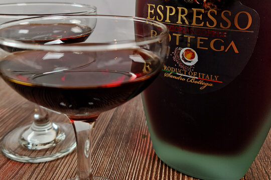 TURKU, FINLAND - March 4, 2023: Coffee liqueur, Expresso, Bottega. A bottle and two glasses on brown table. Close up image.