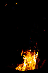 Fototapeta na wymiar The fire burns at night. Fire and sparks on a black background